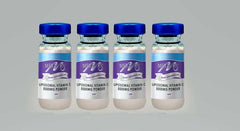 Four unlabeled vials of liposomal vitamin C 5000mg powder with blue caps on gray background